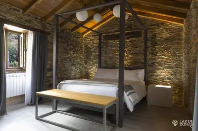a bedroom with a bed and a wooden table at Lar de Donas in Meira