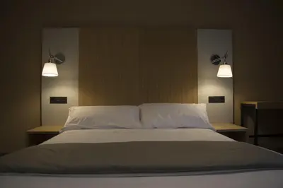 a bed with two pillows and two lights above it at Lar de Donas in Meira