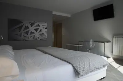 a bedroom with a white bed and a table at Lar de Donas in Meira