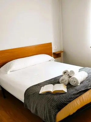 a bedroom with a bed with a book and towels at Figueras 6 in figueras