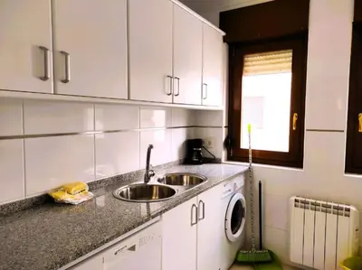 a kitchen with white cabinets and a sink at Figueras 6 in figueras