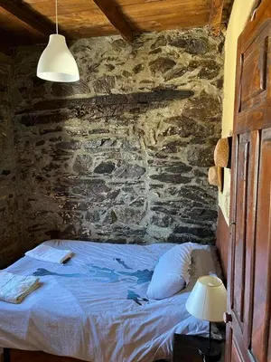 a bedroom with a bed in a stone wall at Medulillas in Yeres