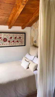 a bedroom with two beds and a wooden ceiling at Casiña Raíz Entre viñas y cielo Ribeira Sacra in Chantada