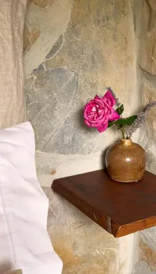 a vase with a pink rose sitting on a table at Casiña Raíz Entre viñas y cielo Ribeira Sacra in Chantada