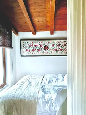 a bedroom with a bed with a floral picture on the wall at Casiña Raíz Entre viñas y cielo Ribeira Sacra in Chantada