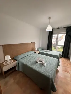 two beds in a hotel room with towels on them at Ilusiones Da Mariña in San Ciprián