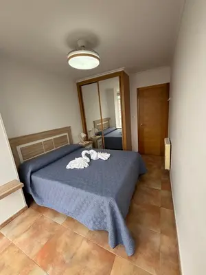 a bedroom with a bed with a blue blanket at Ilusiones Da Mariña in San Ciprián