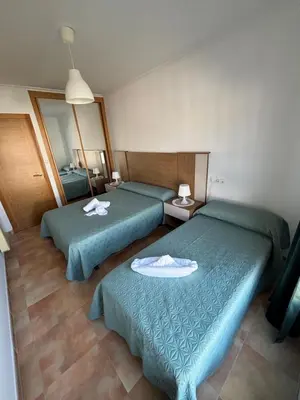two green beds in a room with a mirror at Ilusiones Da Mariña in San Ciprián