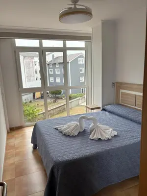 a bedroom with a bed with two swans on it at Ilusiones Da Mariña in San Ciprián