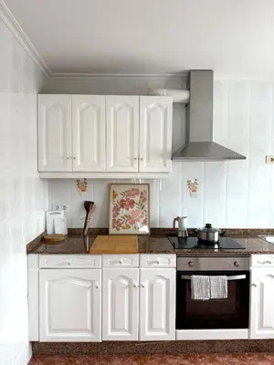 a kitchen with white cabinets and a stove at Piso con terraza y garaje a un Paso de la Playa de Tapia in Tapia de Casariego