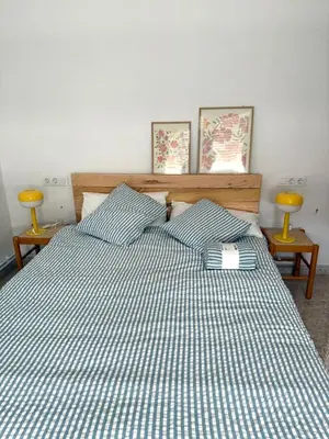 a bed with a blue and white checked comforter at Piso con terraza y garaje a un Paso de la Playa de Tapia in Tapia de Casariego
