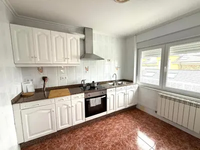 a kitchen with white cabinets and a sink at Piso con terraza y garaje a un Paso de la Playa de Tapia in Tapia de Casariego