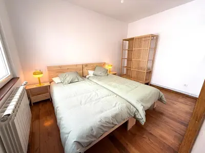a bedroom with a large bed and a wooden floor at Apartamento a Un Paso de la Playa de Tapia in Tapia de Casariego