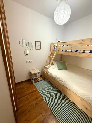 a bedroom with two bunk beds and a lamp at Apartamento a Un Paso de la Playa de Tapia in Tapia de Casariego