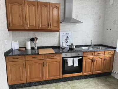 a kitchen with wooden cabinets and a sink at Apartamento a Un Paso de la Playa de Tapia in Tapia de Casariego
