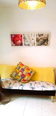 a yellow couch in a room with pictures on the wall at EnFOZ 1ª Línea de Playa II in Foz