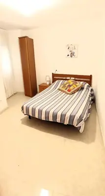 a bedroom with a bed with a striped comforter at EnFOZ 1ª Línea de Playa II in Foz
