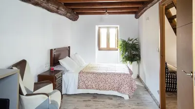 a bedroom with a bed and a chair and a window at AG Casa Brañas, en aldea rural gallega in Aranga