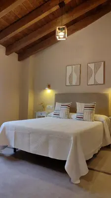 a large white bed in a room with wooden ceilings at Vivienda de Uso Turístico Los Castaños in San Román de Sanabria