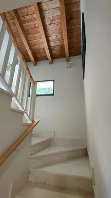 a staircase in a house with wooden ceilings at Vivienda de Uso Turístico Los Castaños in San Román de Sanabria