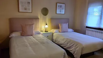 two beds sitting next to each other in a bedroom at Vivienda de Uso Turístico Los Castaños in San Román de Sanabria