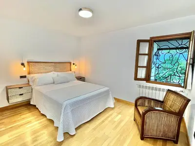 a bedroom with a bed and a stained glass window at Fuentes del Narcea apartamentos rurales in Cangas del Narcea