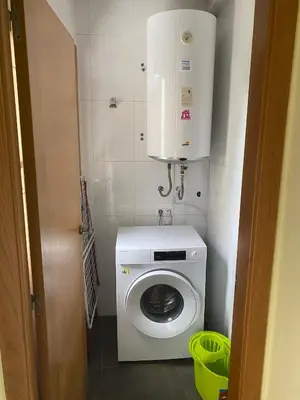a small bathroom with a washing machine and a water heater at Terra 1B in Caldas de Reis
