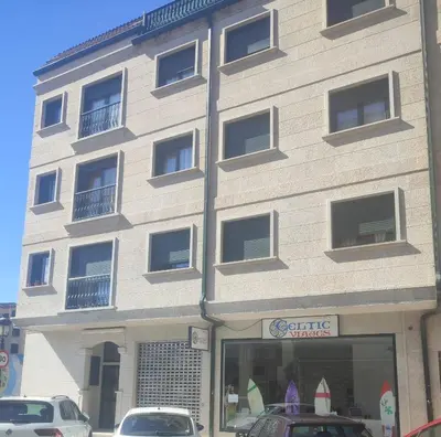 a building with cars parked in front of it at Terra 1B in Caldas de Reis
