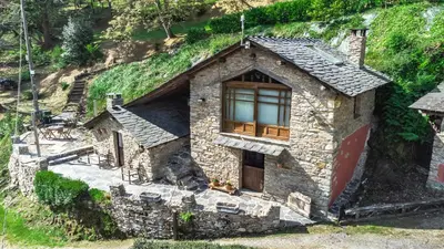 a small stone house on the side of a hill at Villa rural en Playa de Frejulfe in Frejulfe