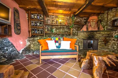 a room with a couch and a stone wall at Villa rural en Playa de Frejulfe in Frejulfe
