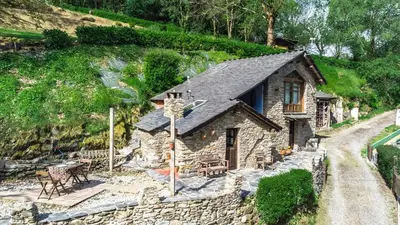 a small stone house with a stone wall at Villa rural en Playa de Frejulfe in Frejulfe