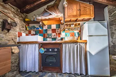 a small kitchen with a stove and a refrigerator at Villa rural en Playa de Frejulfe in Frejulfe