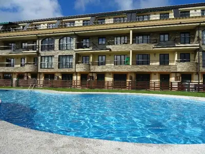 a building with a large pool in front of it at Costa SPA Piscinas de lujo - Playa las Catedrales in Barreiros