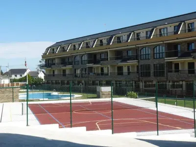 a tennis court in front of a building at Costa SPA Piscinas de lujo - Playa las Catedrales in Barreiros