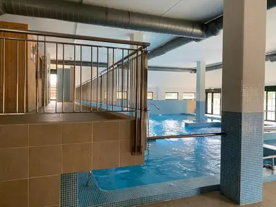 a large swimming pool with blue water in a building at Costa SPA Piscinas de lujo - Playa las Catedrales in Barreiros