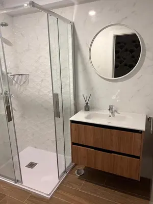 a bathroom with a shower and a sink and a mirror at Sleep Padrón in Padrón