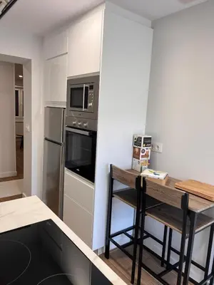 a kitchen with a table and a microwave and a refrigerator at Sleep Padrón in Padrón