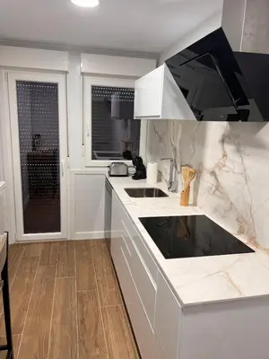 a white kitchen with a sink and a stove at Sleep Padrón in Padrón