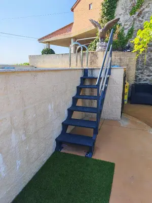 a blue staircase next to a wall with green grass at Vila Riveiro in Vilamelle