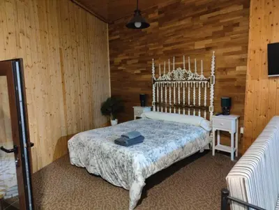 a bedroom with a bed and a wooden wall at Vila Riveiro in Vilamelle