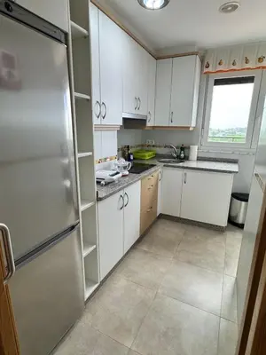 a kitchen with white cabinets and a stainless steel refrigerator at Apartamento Montemar in San Cosme de Barreiros