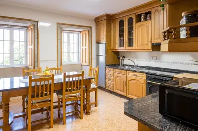 a kitchen with wooden cabinets and a table and chairs at Casa Rural Antonio de Sofia in César