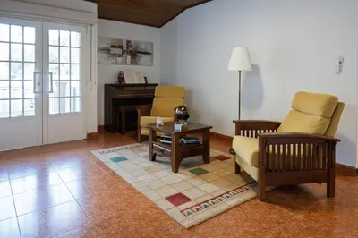 a living room with chairs and a table and a piano at Casa Rural Antonio de Sofia in César