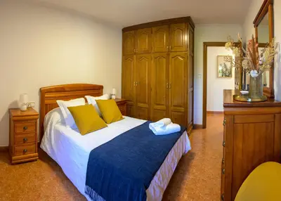 a bedroom with a large bed with yellow pillows at Casa Rural Antonio de Sofia in César