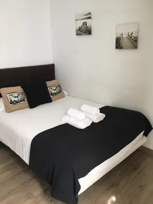 a bedroom with a bed with black and white sheets and towels at Pensión Residencia Fonseca in Santiago de Compostela