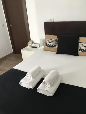 a white bed with two white pillows on it at Pensión Residencia Fonseca in Santiago de Compostela