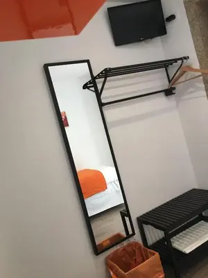 a mirror in a room with a bed and a tv at Pensión Residencia Fonseca in Santiago de Compostela