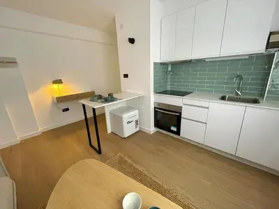 a small kitchen with white cabinets and a sink at Cozy and centrally located apartment in Santiago de Compostela