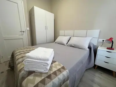 a bedroom with a bed with towels on it at YourHouse Oasis Urbano in Ourense