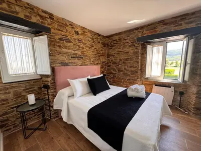 a bedroom with a bed and a brick wall at Pension Silvent in Ribadeo
